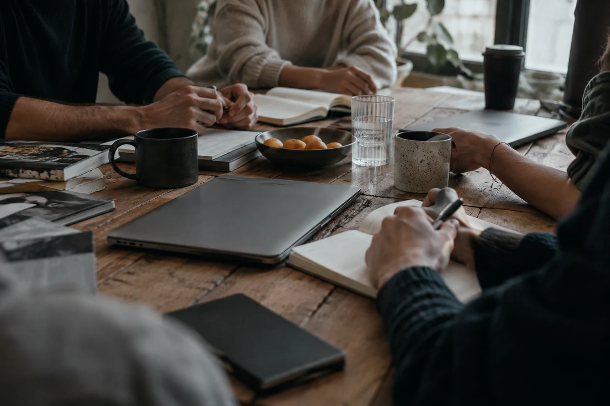 People with laptops and coffee around a shared table, the outbound and reactivation system.